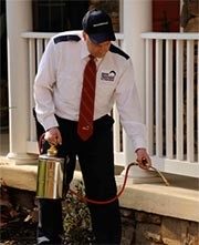 Home Paramount technician spraying outside of a customer's home