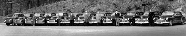 Original Home Paramount employees standing next to a line of cars in 1939